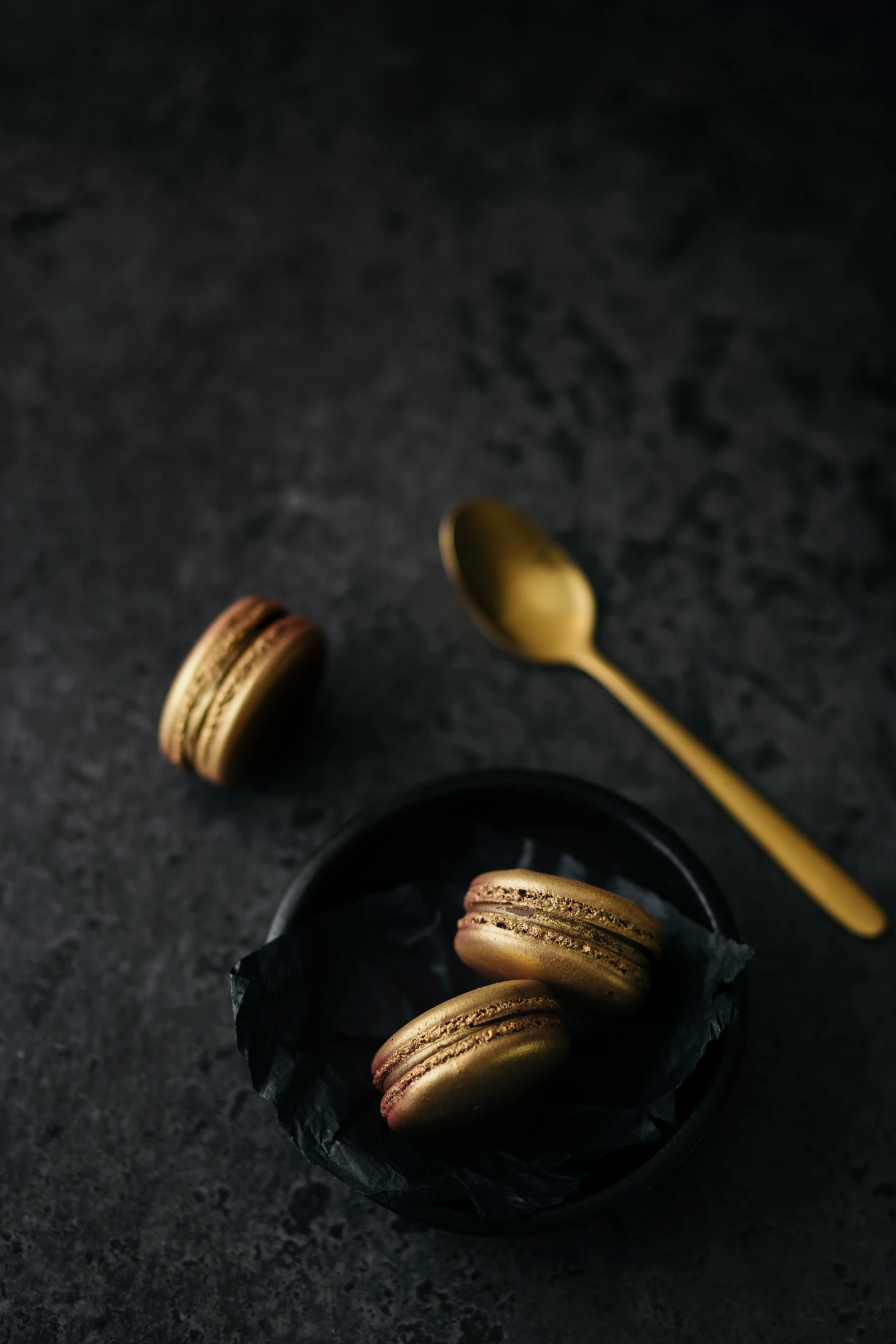 three metallic spoons and three pastries in the plate