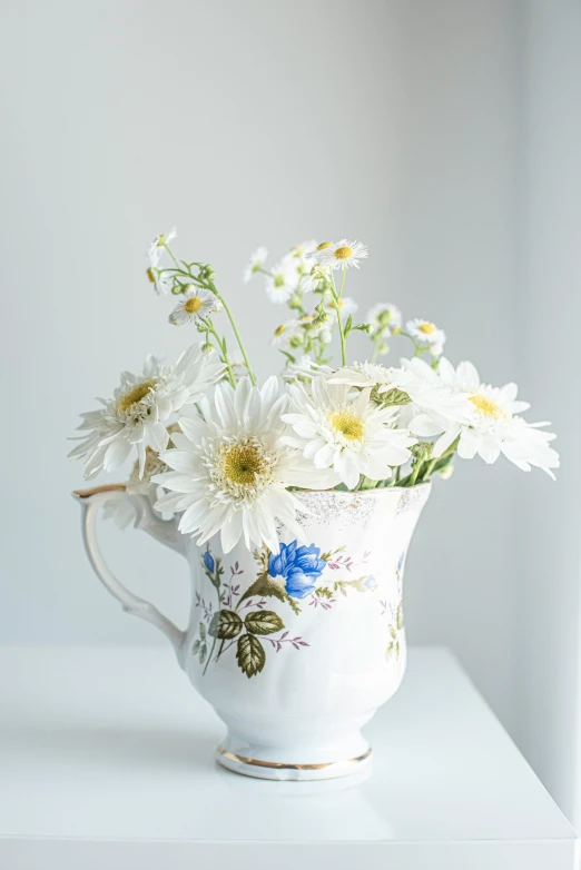 white flowers in a white pitcher on a white counter