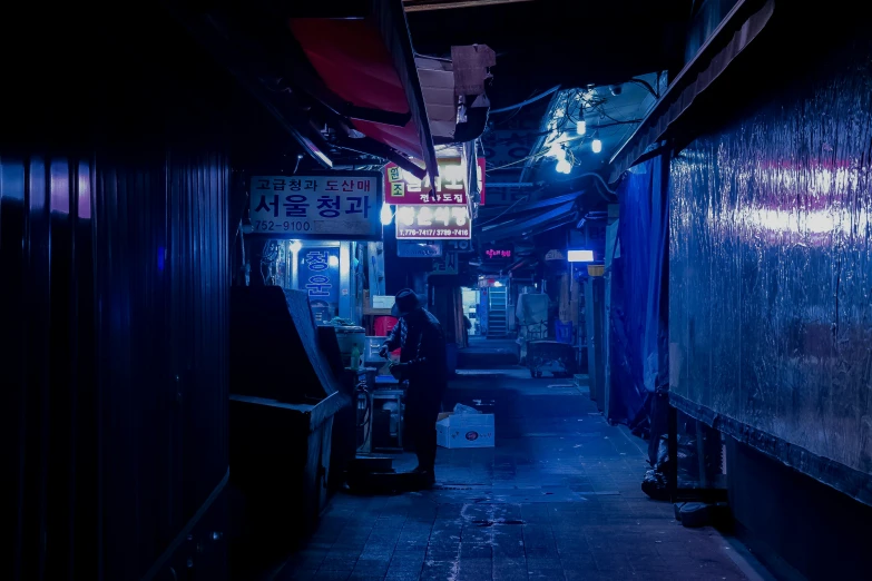 narrow alleyway with people walking down at night