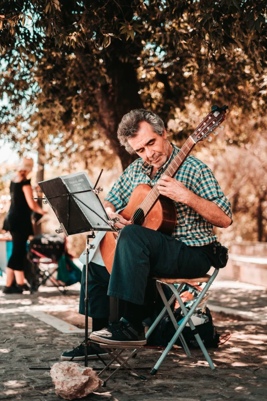 a man playing a guitar in a park