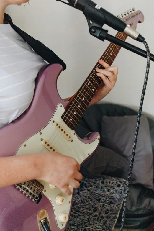 someone is playing on a purple guitar