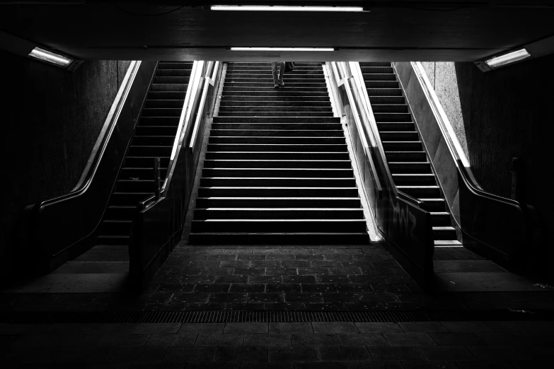 two escalators going up and down, with railings at the bottom