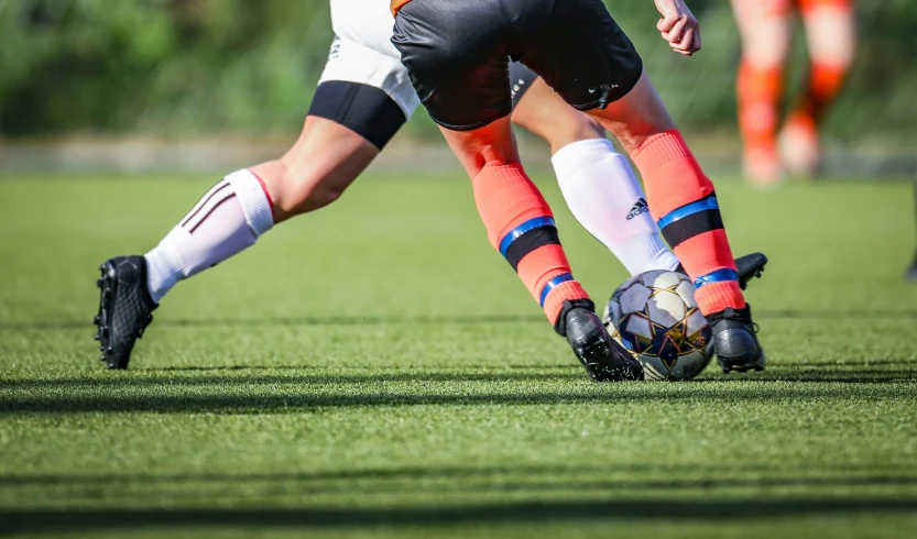 two men are playing soccer together in uniforms