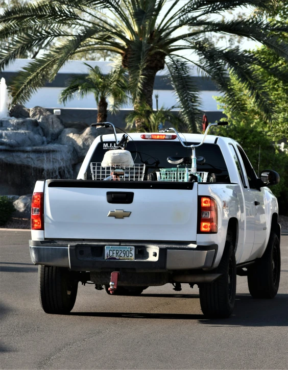 a white truck with baskets on the back is going through a city