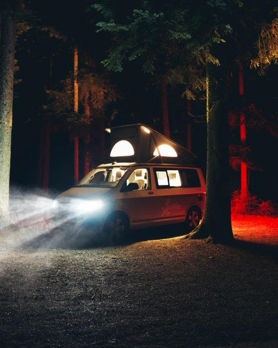 an rv parked in the woods under some lights