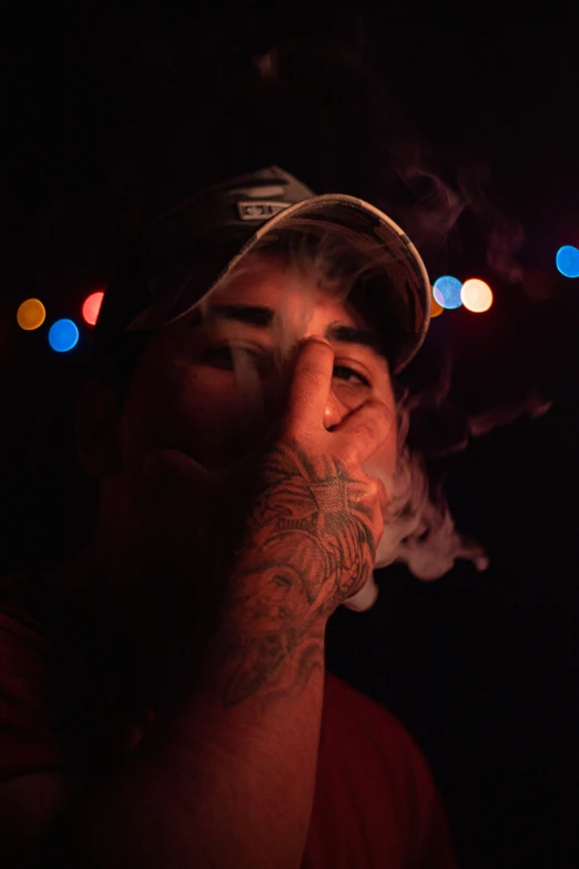 man with hat and beard looking out while smoking a cigarette