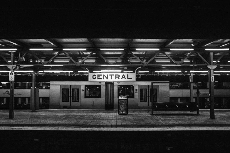 a train station with the word central lit up at night