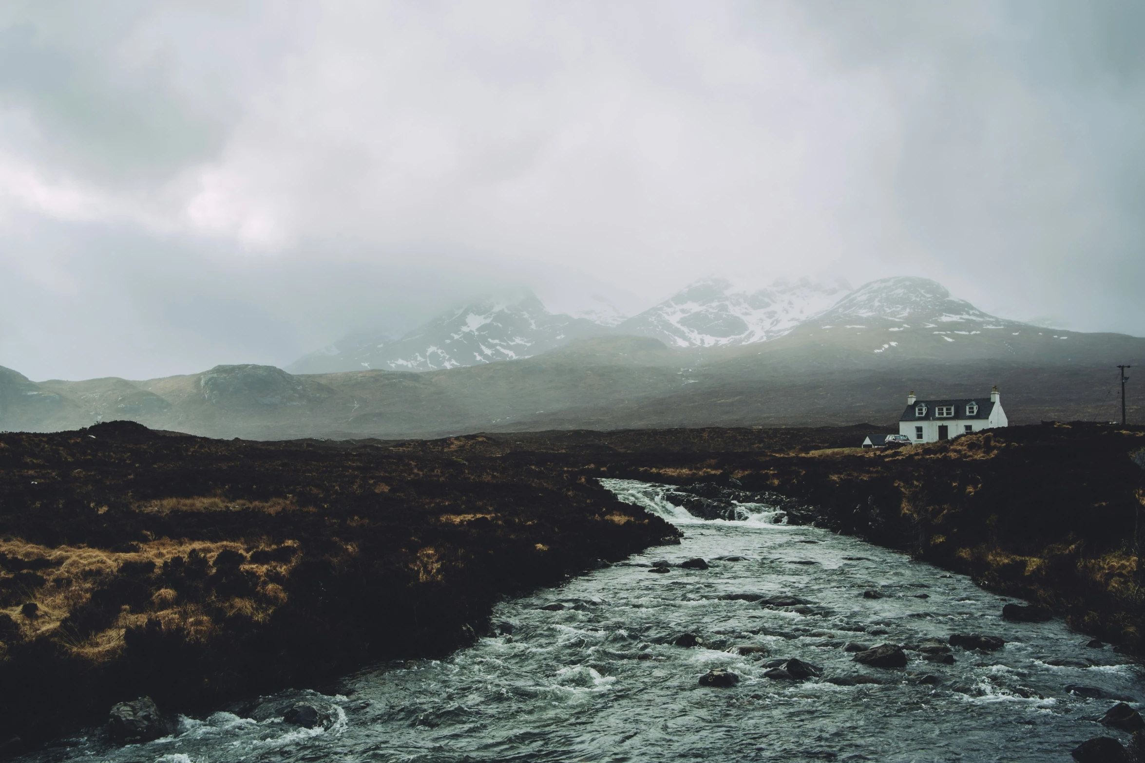 the house is sitting in the valley with a stream