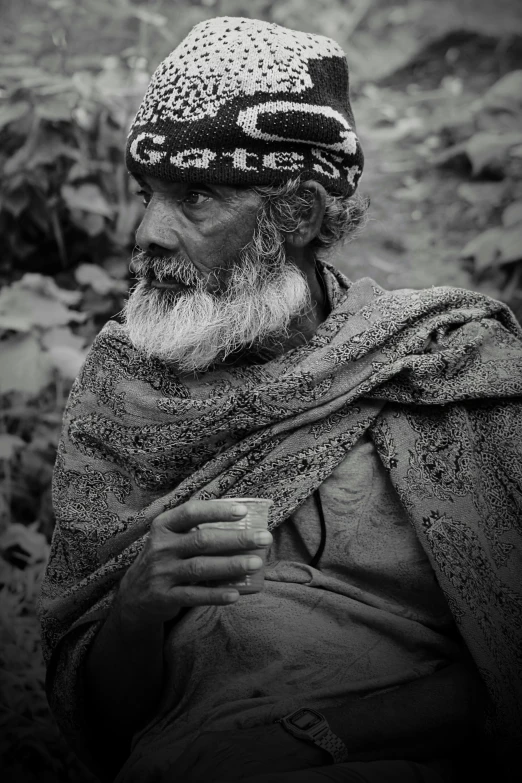 a man with a big beard is holding a cup