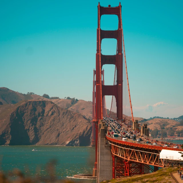 a large red bridge with traffic driving over it