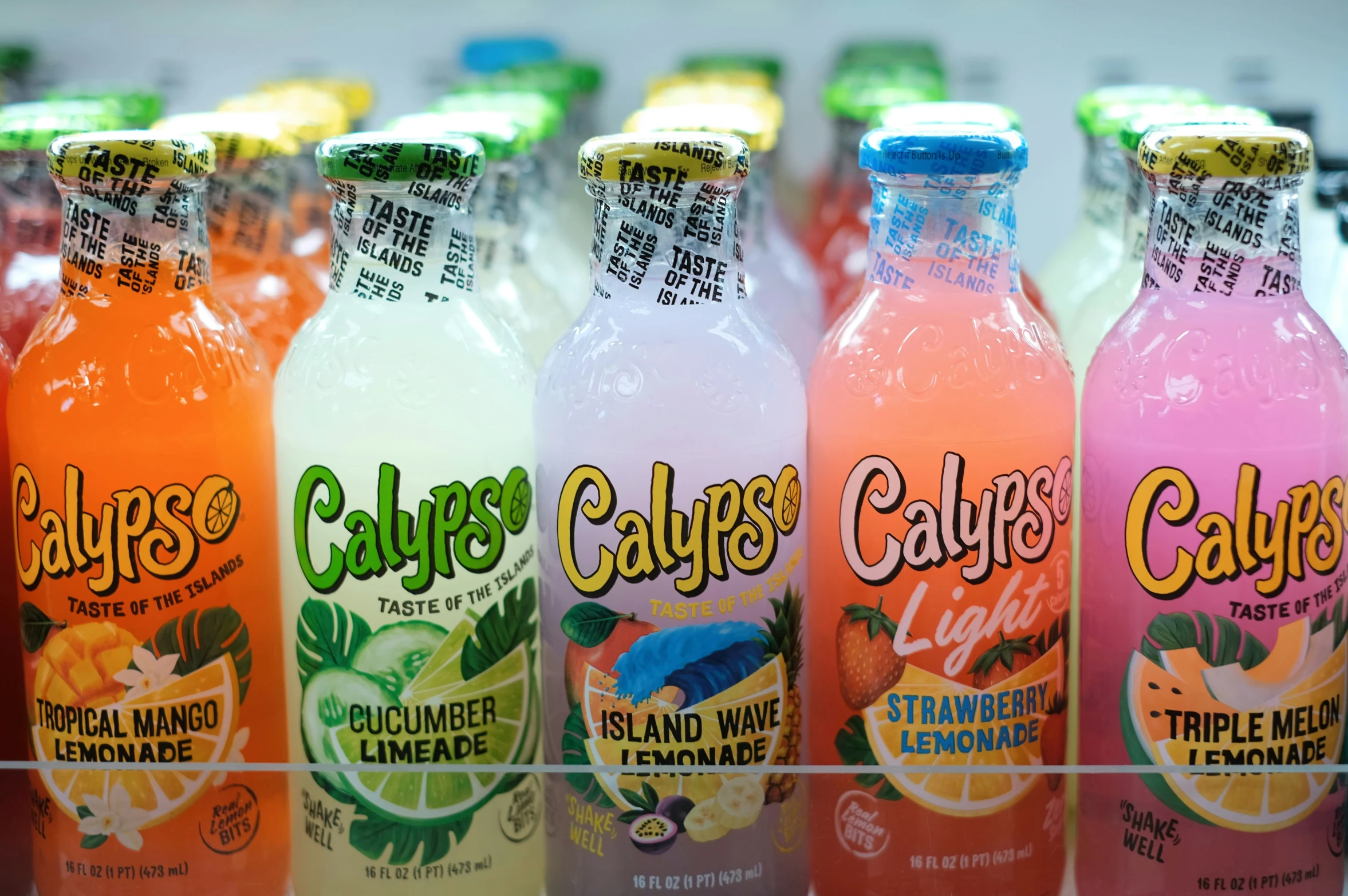 many different types of juice bottles sitting on a shelf