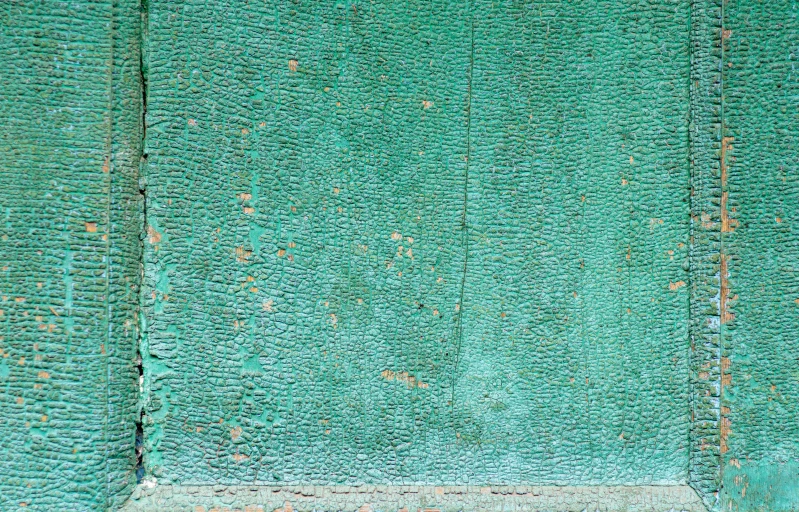 a green wall with a wooden board on the side