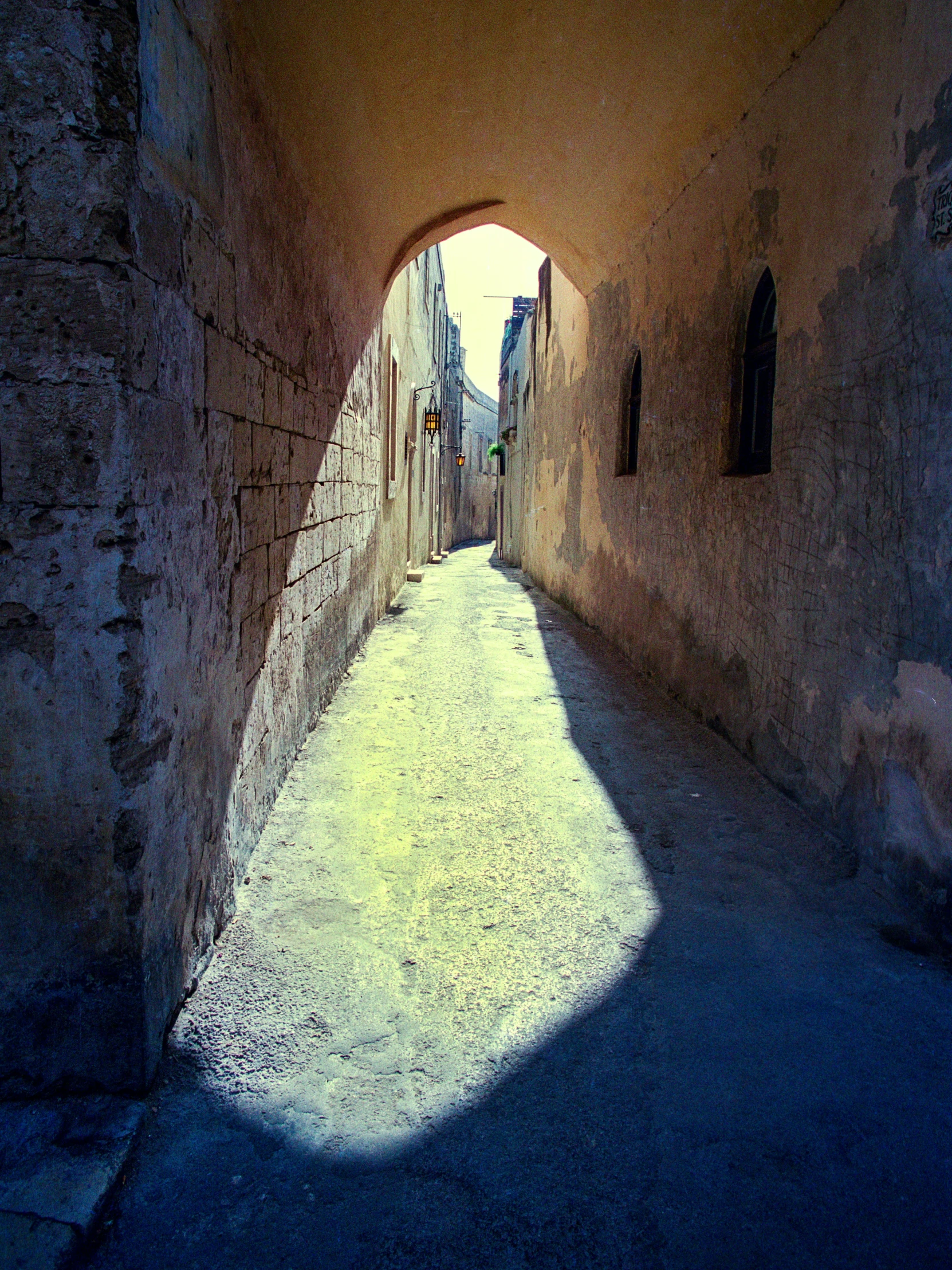 a narrow alley with a few windows near by