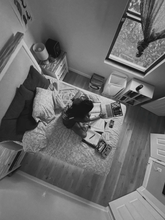 a woman sits on the floor and uses her laptop