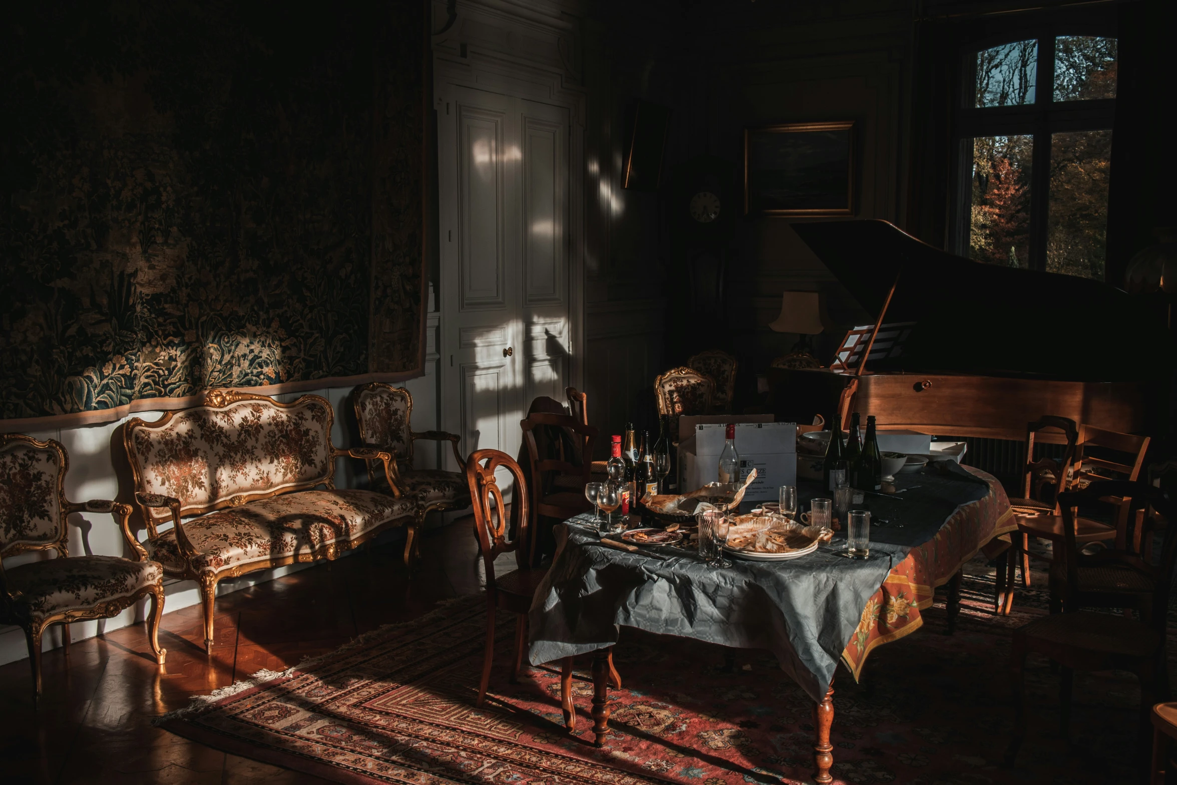 a room with a piano, a chair, and table