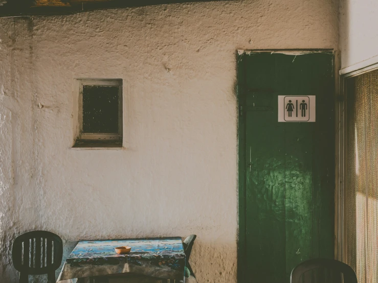 the small room has an old style table and a vintage green door