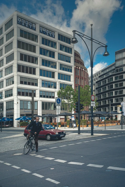 a man riding a bike on the street next to a tall building