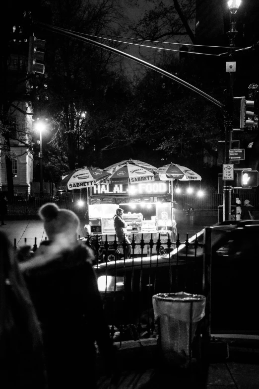 the people are waiting for the food to be served at the outdoor stand