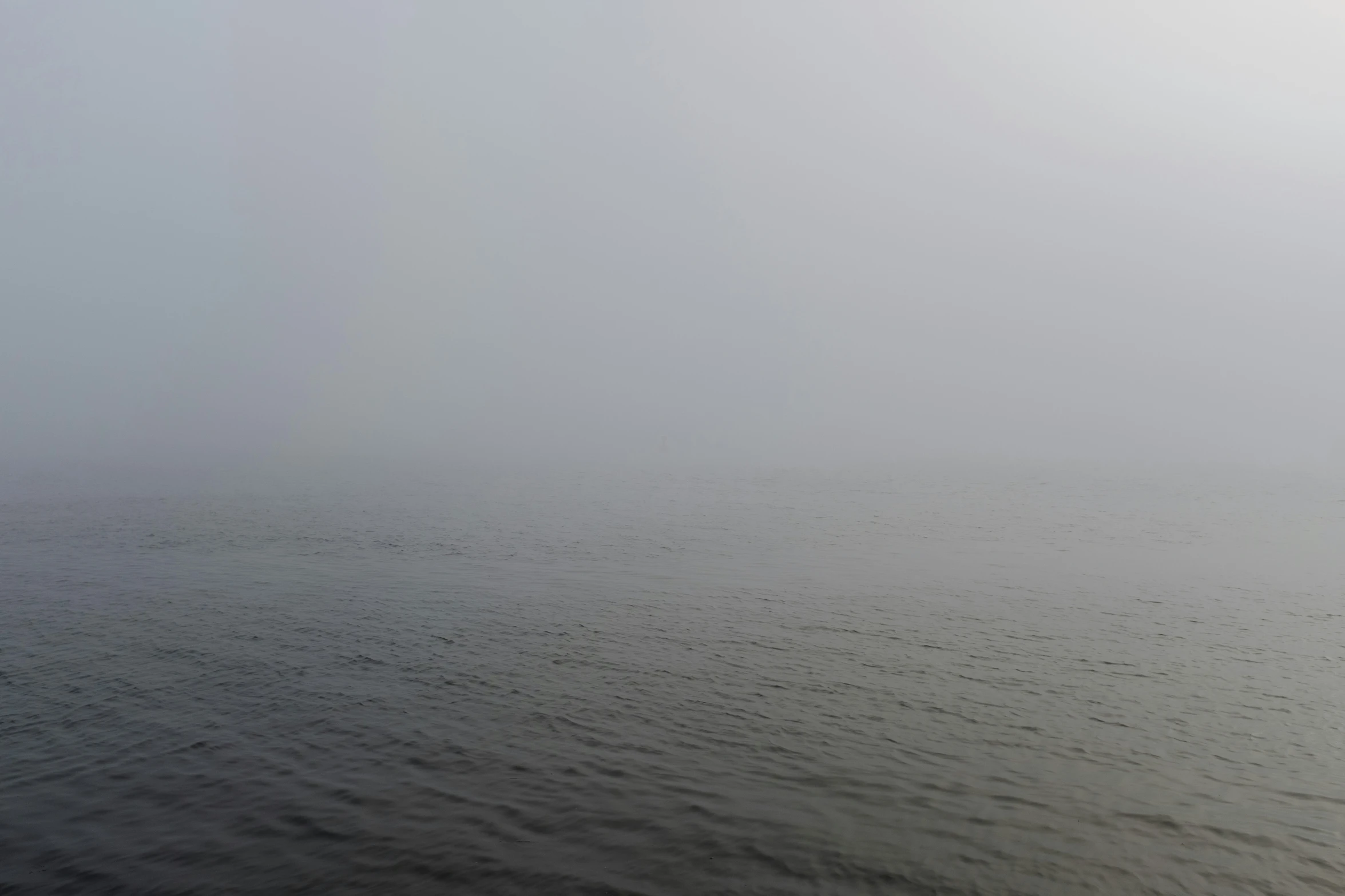 lone sail boat on open ocean in foggy weather