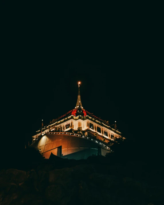 the roof of a building is lit up at night