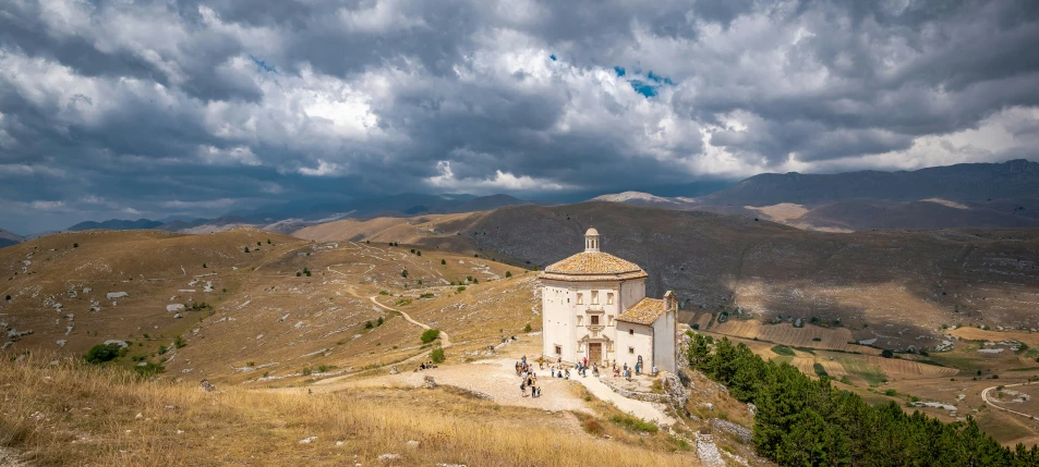 a white tower with a white roof sitting on the side of a mountain