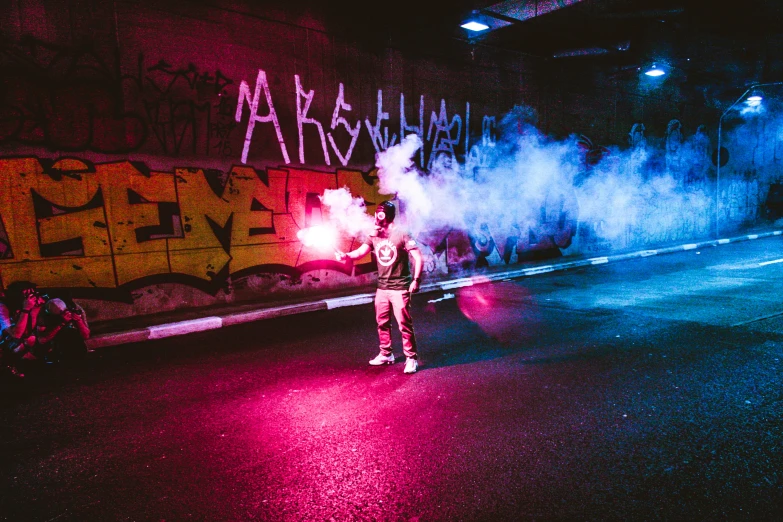 man holding fire breathing device in dark city