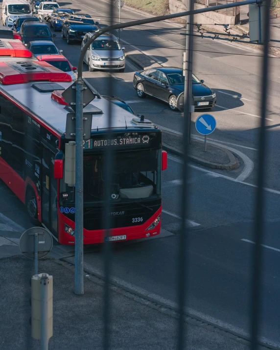 a red and black bus drives down a busy street