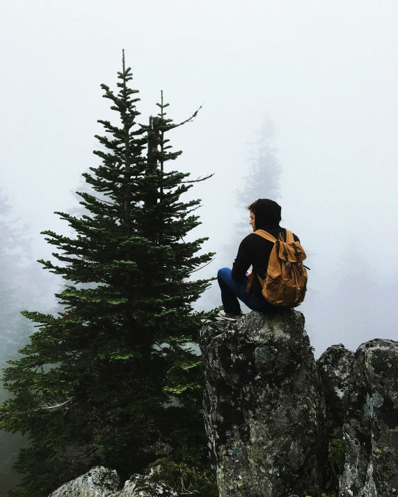 a person sitting on top of a mountain looking down