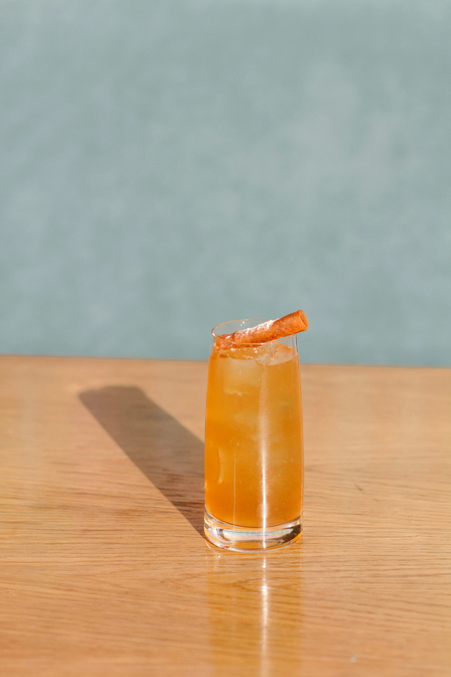 an orange drink in a coupe on a wood table