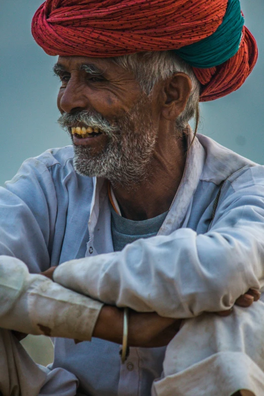 an old man with a bright red turban on his head