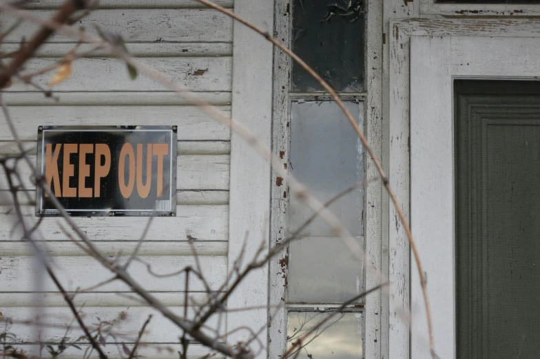 an abandoned door and a sign saying keep out