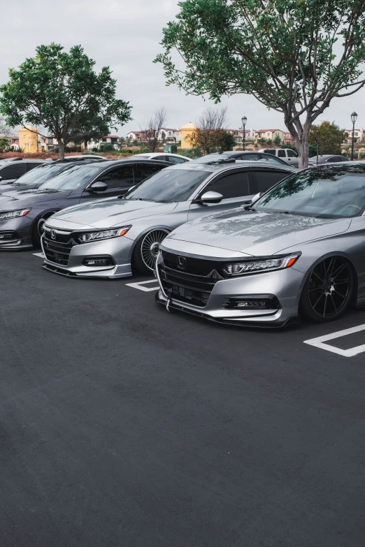 a row of silver cars sitting in a parking lot