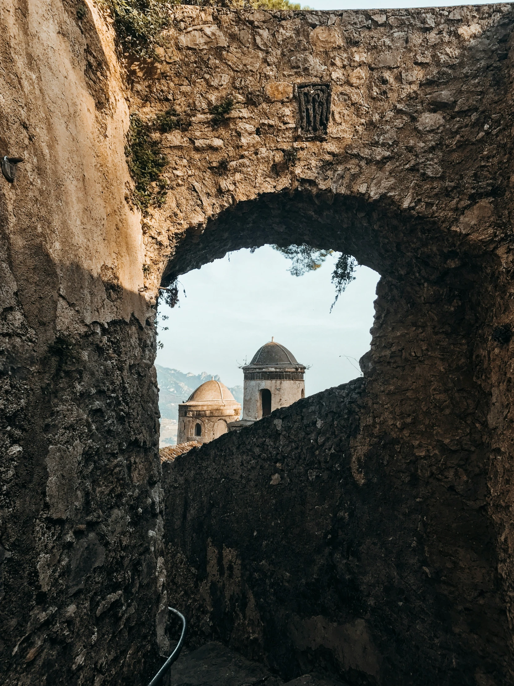 an old stone wall with a window that has an arched view