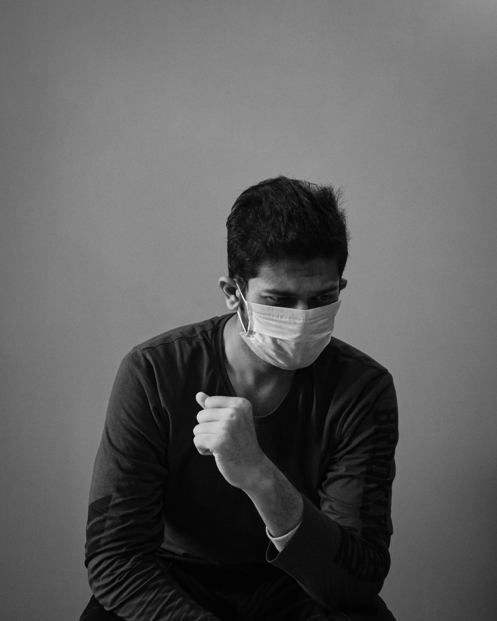 a man wearing a medical mask and holding his fist