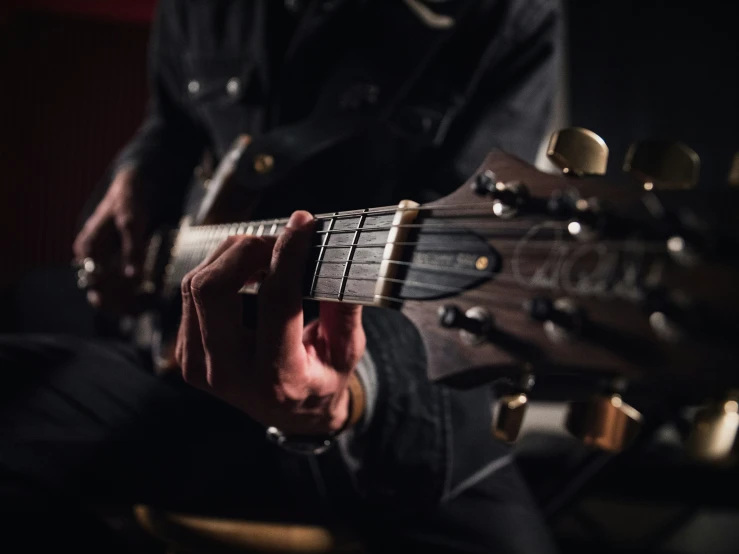 a man playing an electric guitar in the dark