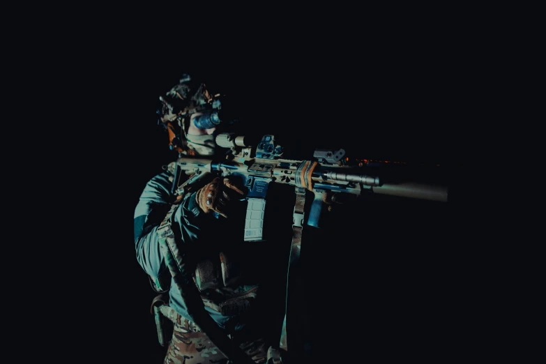 a man is holding a rifle in the dark