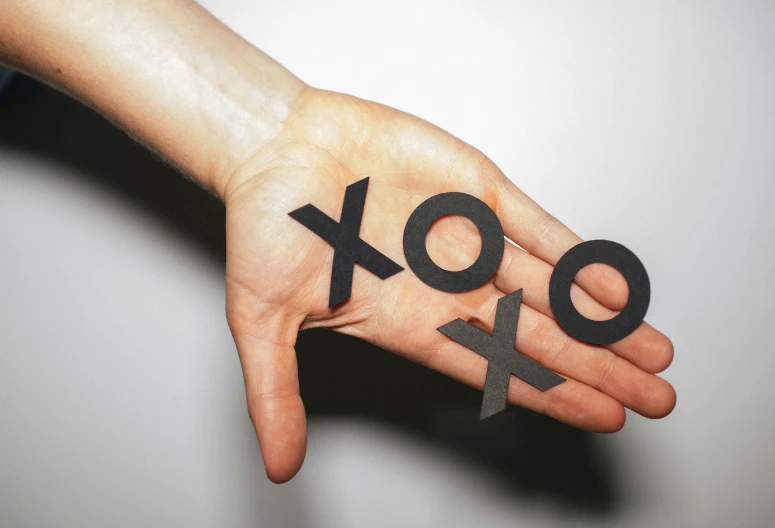 a person holding out their hand with the letters xo and ov painted on it