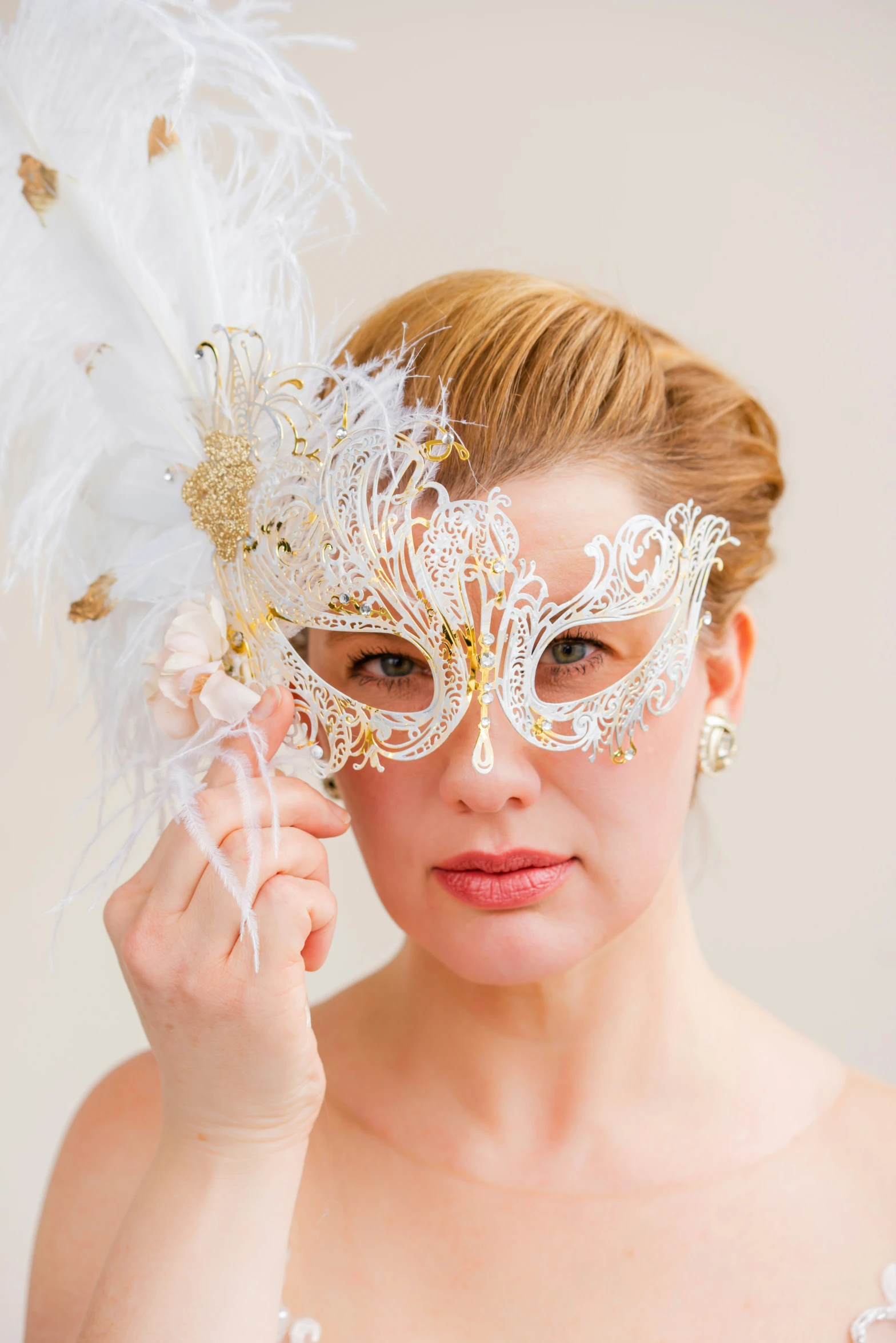 woman wearing a white mask with white feathers