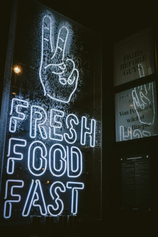 an illuminated sign with hand prints in a building