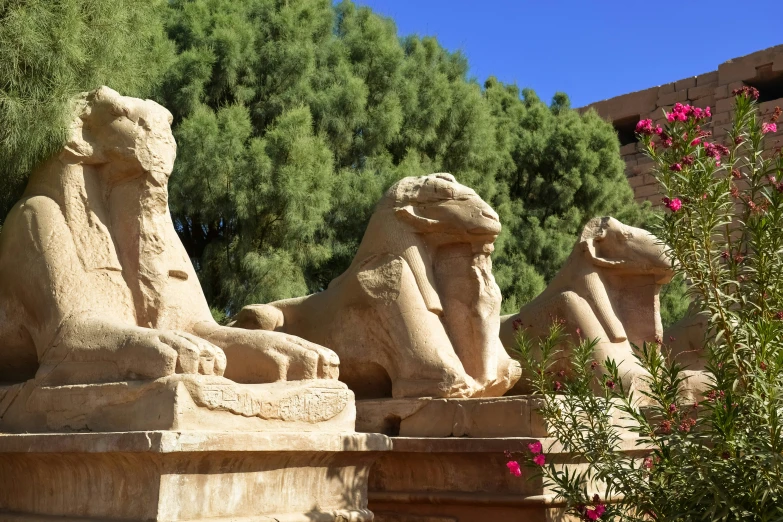 some very big statues next to some trees