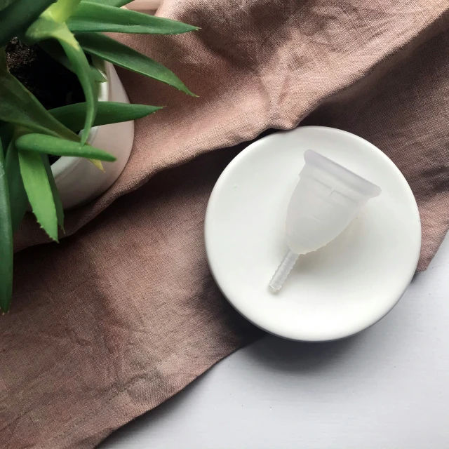 a small cup of water sitting on top of a white plate