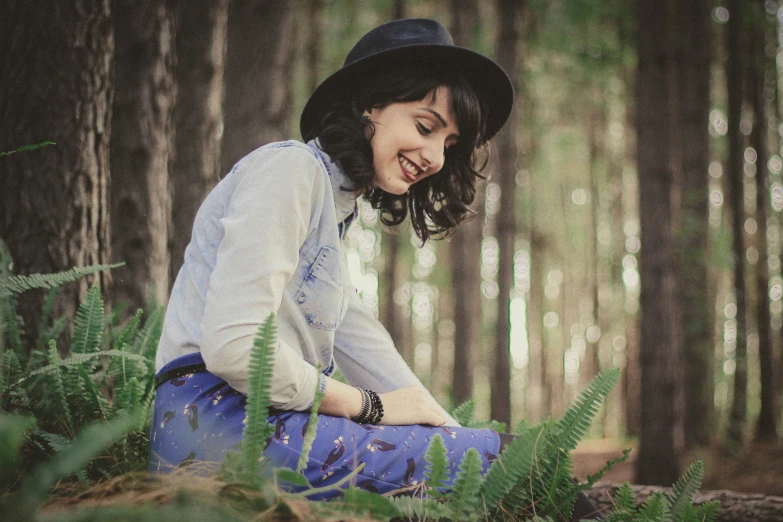 a girl sitting on the ground and smiling