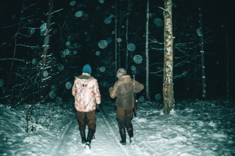 two men walking in a winter wonderland at night
