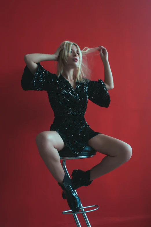 an image of a woman in black on top of a stool