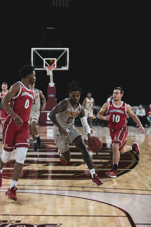 a man drives to the basket as others look on