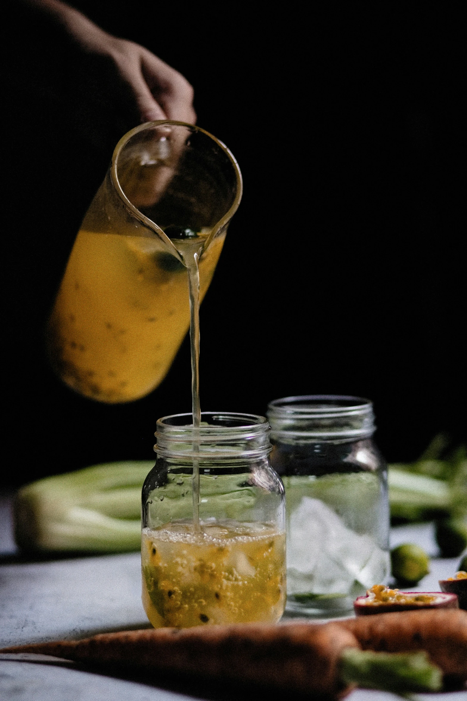 a hand pouring soing into a jar of water