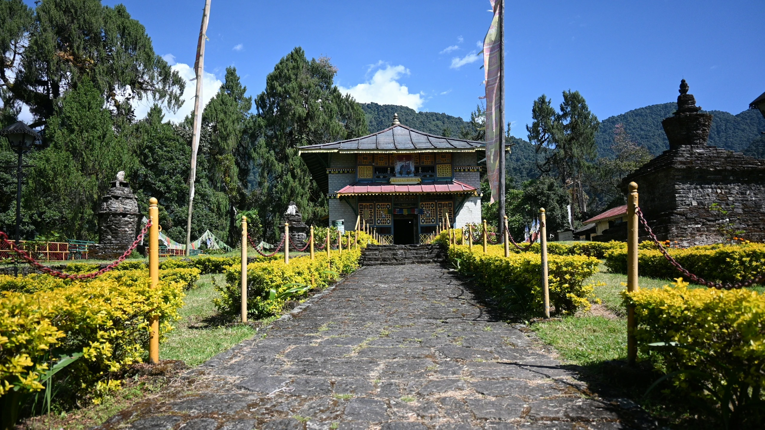 the walkway leads to a temple that is surrounded by beautiful plants