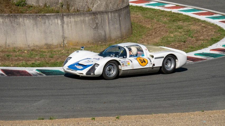 a vintage race car drives down a curved track