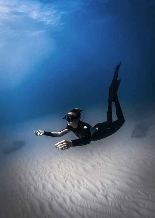 a person scubas under water while holding an object