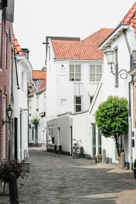 an old european street is lined with white brick buildings and bikes parked along the sidewalk